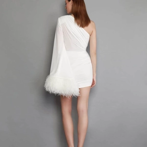 Back view of a white one-shoulder feather dress with flared sleeves and ruched details