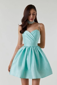 Détail de la robe en satin bleu clair avec décolleté plissé et bretelle en strass