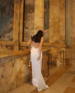 Detail of white satin backless evening gown featuring 3D floral accents on side