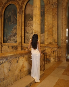 Detail of white satin backless dress featuring 3D floral accents on straps and back