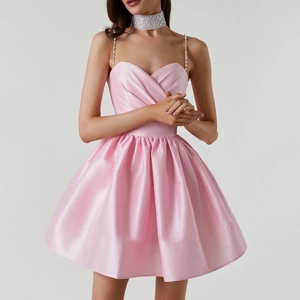 Détails d'une robe en satin rose avec des bretelles en strass et une jupe plissée