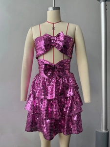 Dettaglio del completo due pezzi con paillettes viola, grande fiocco e bordo a balze
