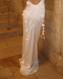 Close-up of the elegant open back with white 3D floral decorations on a white satin dress