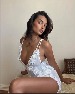 Close-up of delicate 3D floral appliques on a white mesh deep V-neck mini dress