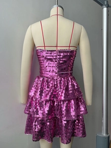 Dettaglio del vestito rosa con paillettes, schiena scoperta e gonna a balze a strati