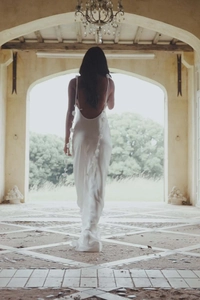Detail of the elegant white backless maxi dress featuring handmade 3D floral decorations