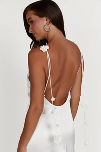 Detail of white satin backless dress with elegant 3D floral applique on the straps