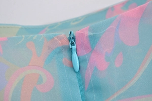 Detail of invisible zipper closure on colorful floral print chiffon summer dress fabric