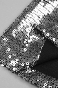 Close-up of the silver sequins on black fabric with a striped pattern of this evening set