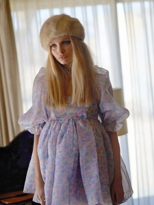 Detailed shot of retro floral puff sleeve dress paired with a stylish faux fur hat