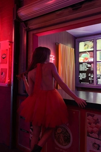 Dettaglio di un abito rosso in tulle a balze con schiena scoperta e lacci per donna