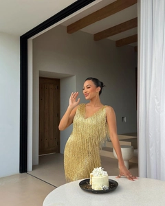 Vue détaillée de la robe dorée à franges avec décolleté en V pour soirée chic