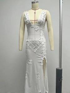 Detailed view of the 3D floral appliques and sheer mesh texture on the white V-neck dress