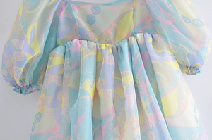 Detail of floral chiffon dress showing puff sleeves and elastic shirred waist texture