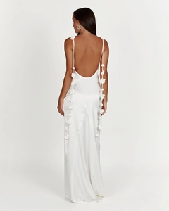 Macro shot of 3D floral accents on the back of a white backless satin vacation maxi dress