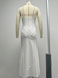 Close-up of 3D floral embroidery and open back detail on a white slim-fit maxi dress