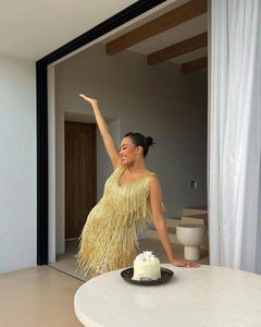 Détail rapproché des franges dorées et paillettes sur une robe de soirée décolleté en V