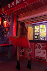Dettaglio di un abito a bambolina in mesh rosso con gonna in tulle a strati vaporosi