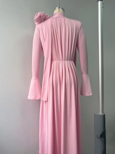 Detailed back view of pink maxi dress with 3D floral accent and pleated drapery