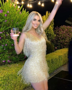 Détail des franges dorées scintillantes sur la robe de soirée avec décolleté plongeant