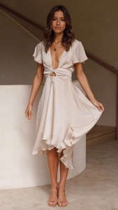 Detailed view of champagne satin dress showing deep V-neck and waist cutout detail