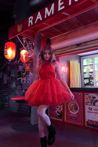 Dettaglio abito rosso in tulle con gonna a rete a strati e vita attillata per feste