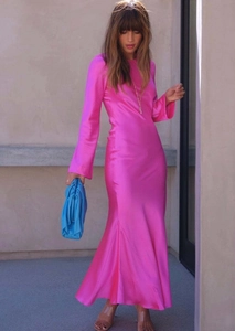 Détail de la robe sirène en satin rose fuchsia avec manches longues et coupe ajustée