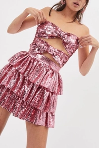 Dettaglio completo di set rosa con paillettes composto da top a fascia e gonna a balze