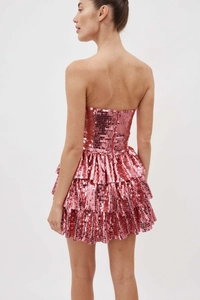 Dettaglio del mini abito rosa con paillettes, gonna a balze e cerniera invisibile sul retro