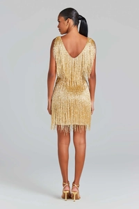 Détail d'une robe dorée à paillettes avec un dos nu en V profond et des franges