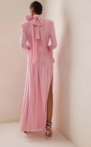 Exaggerated large bow detail on the back of a pink halter neck satin evening dress