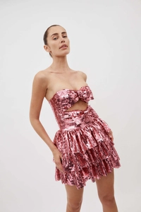 Dettaglio dell'abito rosa con paillettes, fiocco cut-out e gonna a balze a strati