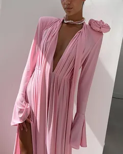 Detailed view of deep V-neckline with 3D rose flower and flared sleeves on pink maxi dress