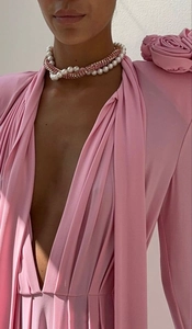 Detail of the elegant deep V-neckline with delicate pleats and a floral 3D rose accent