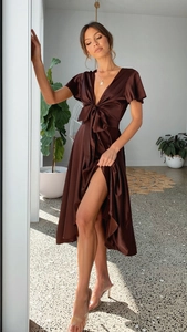 Close-up of brown satin dress featuring a deep V-neck, waist bow, and ruffled short sleeves