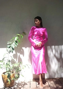Détail de la texture d'une robe en satin rose fuchsia à manches longues et coupe sirène