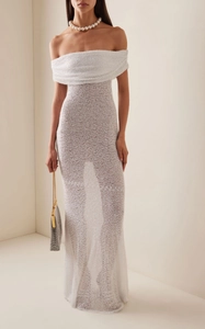 Détail de la robe pailletée blanche élégante avec col bardot et tissu scintillant brillant