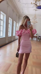Détail de la robe rose à épaules dénudées avec volants et coupe mini jupe ajustée