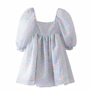 Detailed close-up of floral print fabric with square neck and puff sleeves on girl's dress