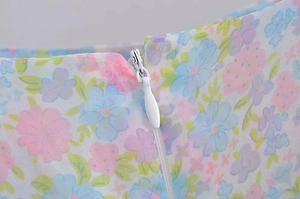 Close-up of invisible white zipper on floral vintage dress with pastel flower print