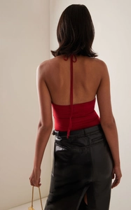 Detail of red backless halter top showing tie-neck design and black leather skirt