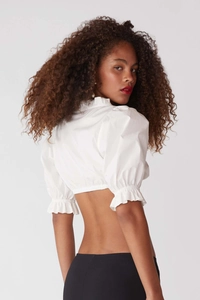 Vue arrière du crop top blanc avec manches bouffantes et détails de volants élégants