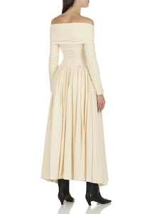 Détail d'une robe beige chic à épaules dénudées avec manches plissées et tissu texturé