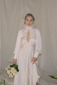 Detail of elegant white satin wedding dress with high neck and V-slit chest cutout