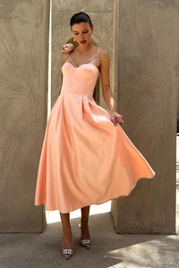 Dettaglio dell'abito bustier rosa pesca con un grande fiore 3D decorativo sulla spalla