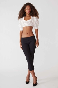 Détail du crop top blanc à manches bouffantes avec bords volantés et col carré chic