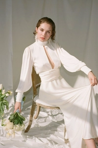 Detail of white satin dress featuring high neck, hollow-out chest and puffy lantern sleeves