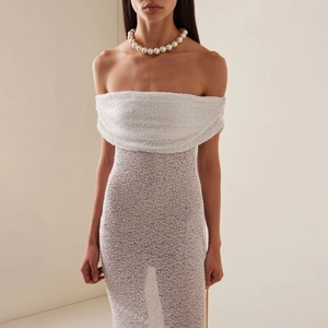 Robe de soirée élégante à paillettes blanches, épaules dénudées et collier de perles