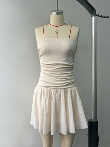 Detail of elegant pleated cream corset top and layered mesh skirt on mannequin