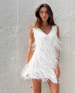 Détail de la robe de cocktail blanche à paillettes avec franges et décolleté en V